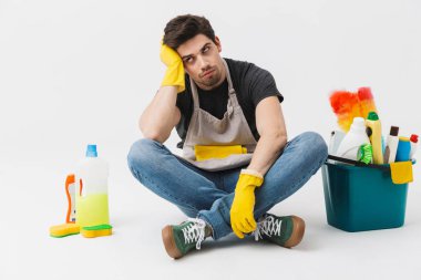 Beyaz duvar arka plan üzerinde izole katta temizleyiciler ile yorgun sıkılmış genç ev kadını househusband.