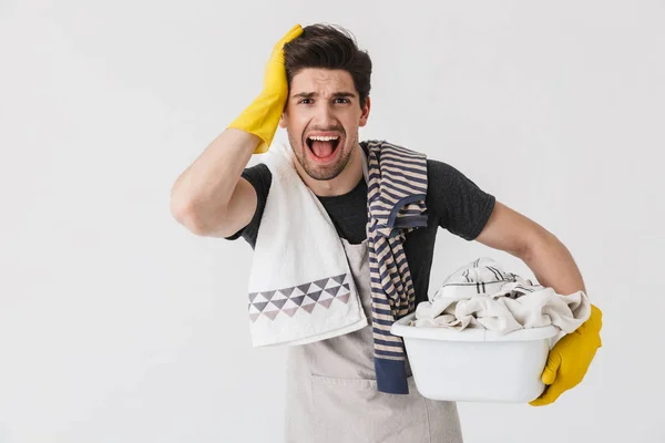 Foto do jovem irritado usando luvas de borracha amarela fazendo — Fotografia de Stock