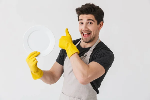 Photo of brunette young man wearing yellow rubber gloves for han — Stock Photo, Image