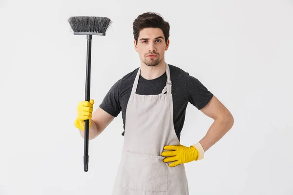 Foto de um jovem forte usando luvas de borracha amarela para as mãos — Fotografia de Stock