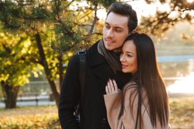Park doğasında açık havada sarılma yürüyüş poz güzel seven çift.