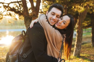 Park doğasında açık havada sarılma yürüyüş poz güzel seven çift.