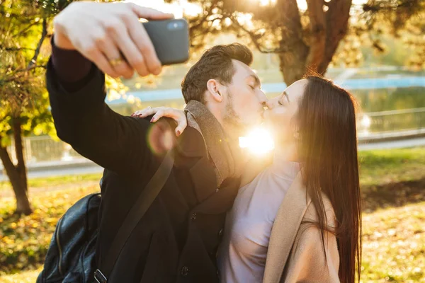 Piękny kochający para pozowanie chodzenie na dworze w Park natura brać selfie przez zdejmowany telefon. — Zdjęcie stockowe