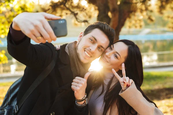 Belo casal amoroso posando andando ao ar livre no parque natureza tirar selfie por telefone móvel . — Fotografia de Stock