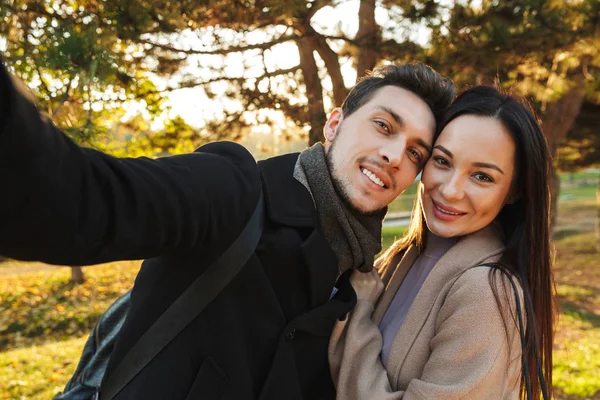 Boldog fiatal gyönyörű szerető pár jelentő séta a szabadban a Park jellege vegye selfie a kamera. — Stock Fotó