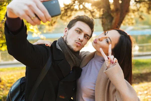 Bella coppia amorevole posa passeggiando all'aperto nel parco natura prendere selfie dal telefono cellulare . — Foto Stock