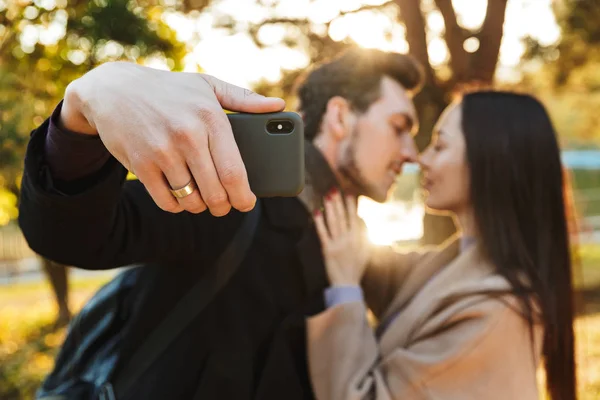 Beautiful loving couple posing walking outdoors in park nature take selfie by mobile phone. — Stock Photo, Image