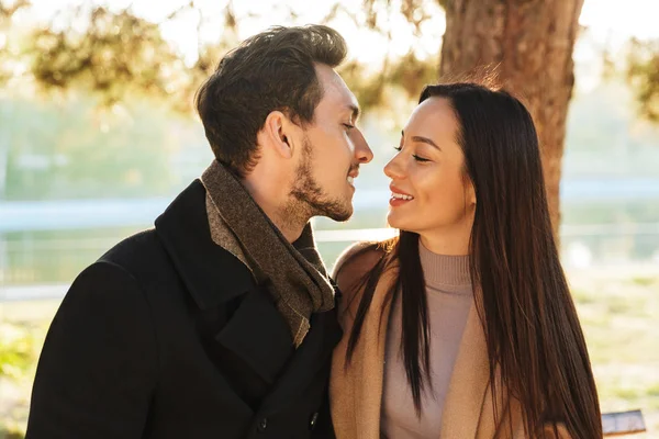 Heureux jeune beau couple aimant posant en plein air dans le parc nature baisers . — Photo