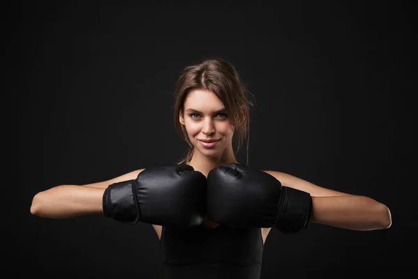 Retrato de mulher branca atlética em sportswear posando na câmera com luvas de boxe durante o treino no ginásio — Fotografia de Stock