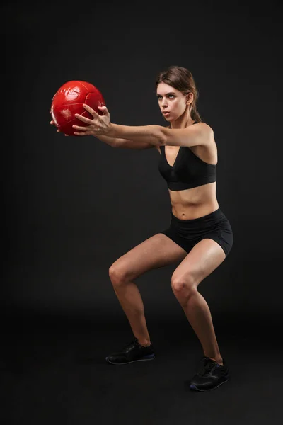 Volledige lengte portret van skinny Kaukasische vrouw in Sportswear doen sit-ups met fitness bal tijdens de training in de sportschool — Stockfoto