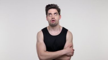 Siyah gömlek li mutsuz genç sakallı sportif adam, izole gri arka plan üzerinde kameraya bakarken yorucu oluyor