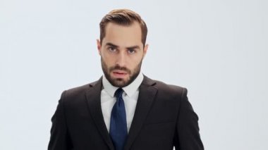 Siyah takım elbiseli ve mavi kravatlı ciddi genç işadamı derinden iç çekiyor ve bir şeye hazırlanıyor.