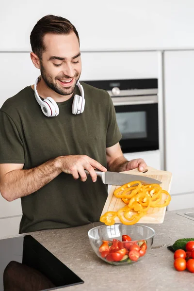 キッチン料理で屋内で幸せな若いひげの男は朝食を持っています. — ストック写真