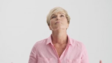 Dua rahatlatıcı sakin sarışın yaşlı kadın yakından görünümü gri arka plan izole üzerinde elleri bir arada tutarak poz