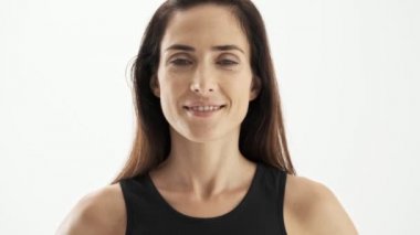 Beyaz arka plan izole üzerinde kameraya bakarken gülümseyen siyah spor esmer kadın yakından görünümü