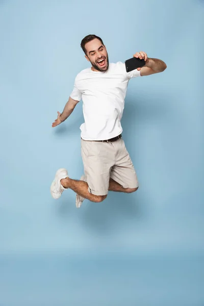 Full length photo of unshaved caucasian man in casual white t-sh