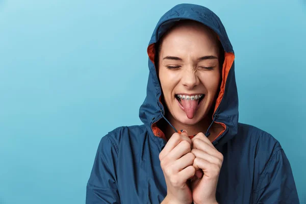 Porträt eines fröhlichen jungen Mädchens im Regenmantel stehend — Stockfoto