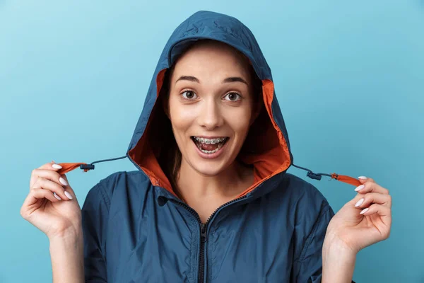 Porträtt av en glad ung flicka som bär regnrock stående — Stockfoto