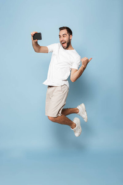 Full length photo of optimistic caucasian man in casual white t-