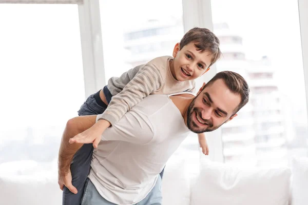 Gelukkige vader en zijn zoon piggyback rijden — Stockfoto