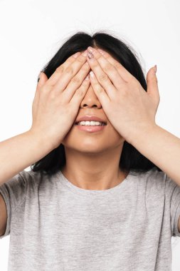 Asyalı güzel genç kadın gözleri kaplayan beyaz duvar arka plan üzerinde izole poz.