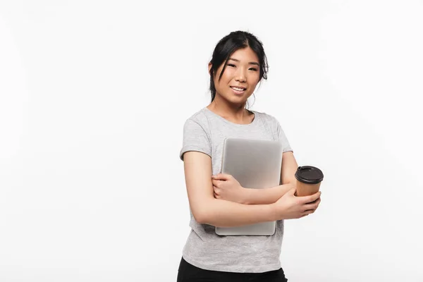 Asiático hermosa joven mujer posando aislado sobre blanco pared fondo bebiendo café celebración ordenador portátil . —  Fotos de Stock