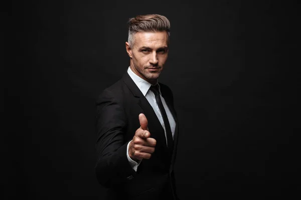 Portrait of serious manly businessman dressed in formal suit pointing finger and looking at camera — Stock Photo, Image