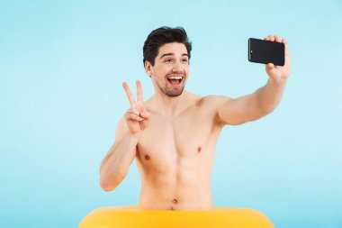 Neşeli gömleksiz adam mavi üzerinde izole ayakta