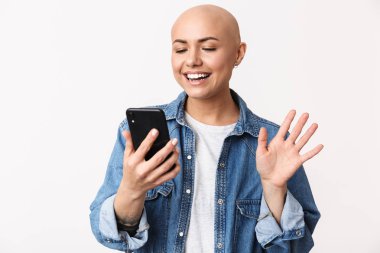 Güzel mutlu kel kadın cep telefonu ile konuşurken beyaz duvar arka plan üzerinde izole poz.