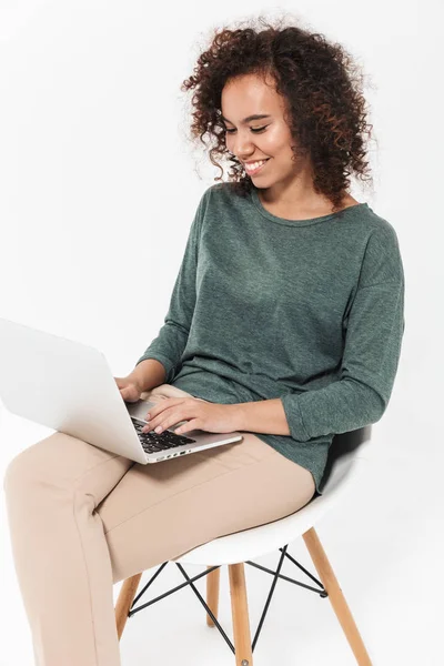 Attraktive junge Afrikanerin sitzt auf einem Stuhl — Stockfoto