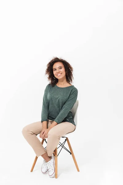 Jovem mulher africana atraente sentada em uma cadeira — Fotografia de Stock