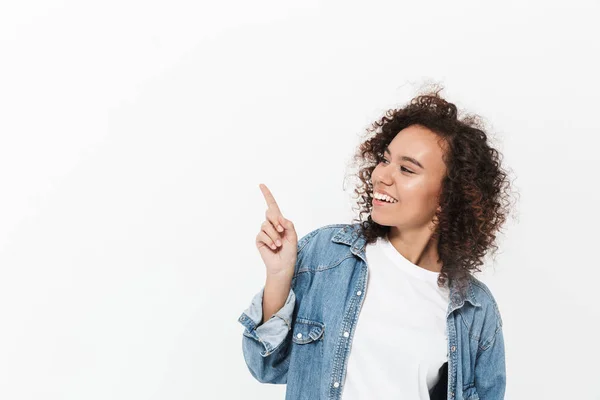 Linda animado emocional jovem feliz mulher africana posando isolado sobre fundo da parede branca apontando . — Fotografia de Stock