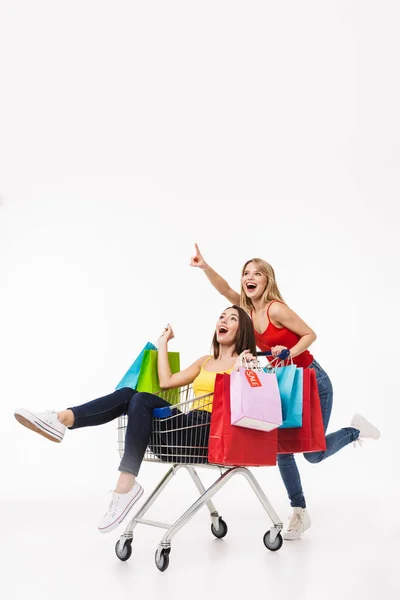 Longitud completa de dos alegres chicas jóvenes bonitas aisladas — Foto de Stock