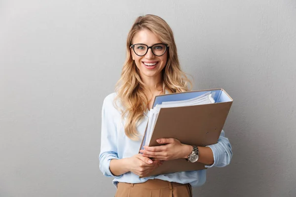 Pretty blonde business woman posing isolated grey wall background holding folder.