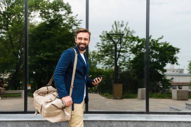 Çekici genç sakallı adam ceket yürüyüş giyiyor