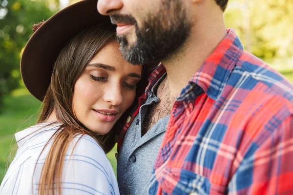 Imagen de la hermosa pareja hombre y mujer abrazándose juntos mientras caminan en el parque verde — Foto de Stock