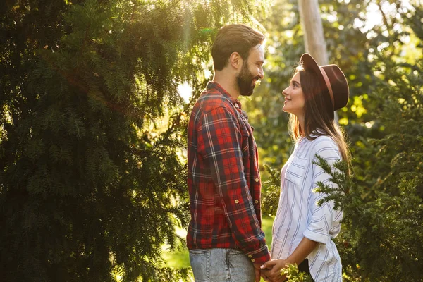 Imagen de la hermosa pareja hombre y mujer riendo mientras se miran en el parque verde — Foto de Stock