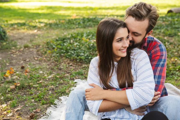 Bild eines schönen Paares, das sich im grünen Park umarmt — Stockfoto