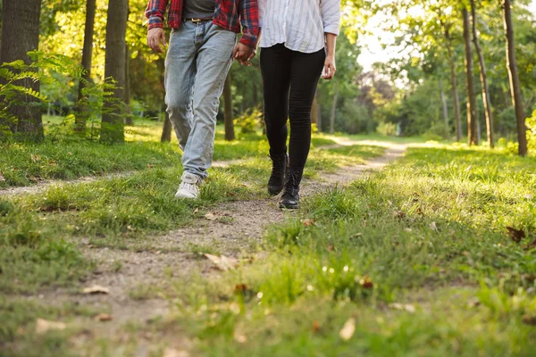 Foto recortada de um jovem casal amoroso andando ao ar livre em uma floresta verde parque natural . — Fotografia de Stock