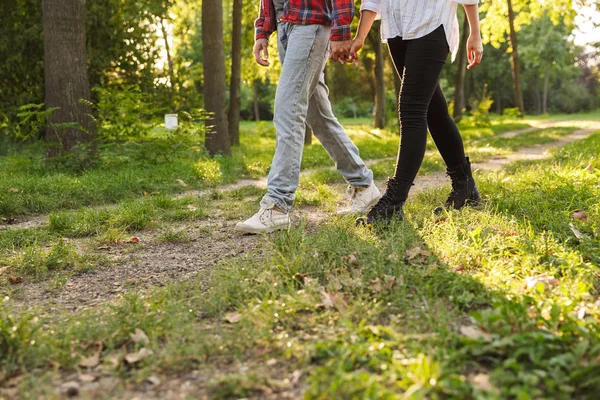Yeşil bir doğa parkı ormanda açık havada yürüyen genç bir sevgi dolu çift kırpılmış resim. — Stok fotoğraf