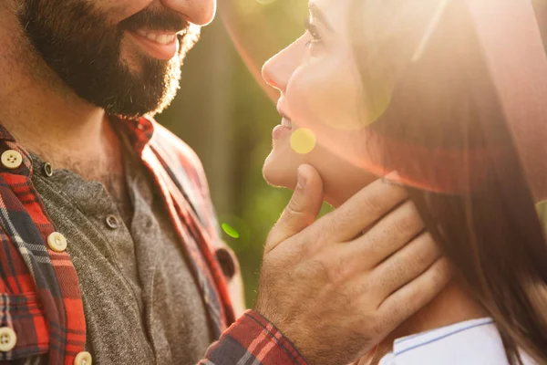 Alegre satisfeito romântico jovem casal amoroso andando ao ar livre em um verde natureza parque floresta beijando . — Fotografia de Stock