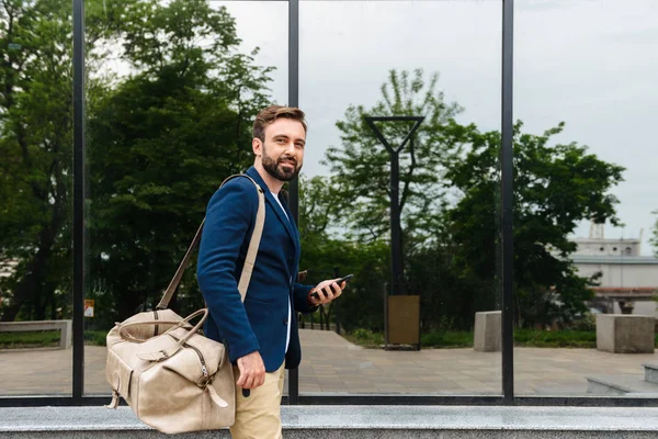 Attraktiver junger bärtiger Mann mit Jacke zu Fuß — Stockfoto