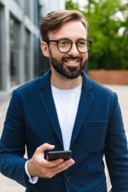 Çekici gülümseyen genç sakallı adam ceket giyiyor