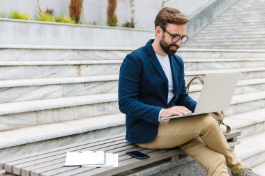 Yakışıklı gülümseyen genç sakallı adam ceket giyiyor