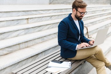 Yakışıklı gülümseyen genç sakallı adam ceket giyiyor