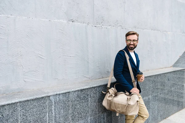 Ritratto di uomo d'affari soddisfatto che indossa occhiali che beve caffè da tazza di carta e borsa da trasporto — Foto Stock