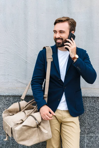 Retrato del hombre de negocios masculino con chaqueta hablando por celular y bolsa de mano — Foto de Stock