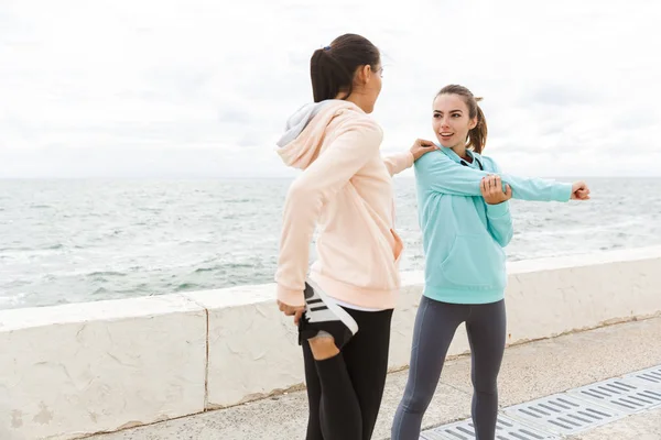 Dos jóvenes y atractivas mujeres de fitness con sudaderas — Foto de Stock