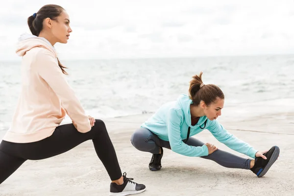 Két vonzó fiatal fitnesz nők visel kapucnis — Stock Fotó