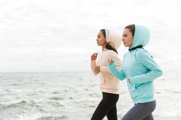 Dos hermosas mujeres jóvenes fitness corriendo al aire libre — Foto de Stock